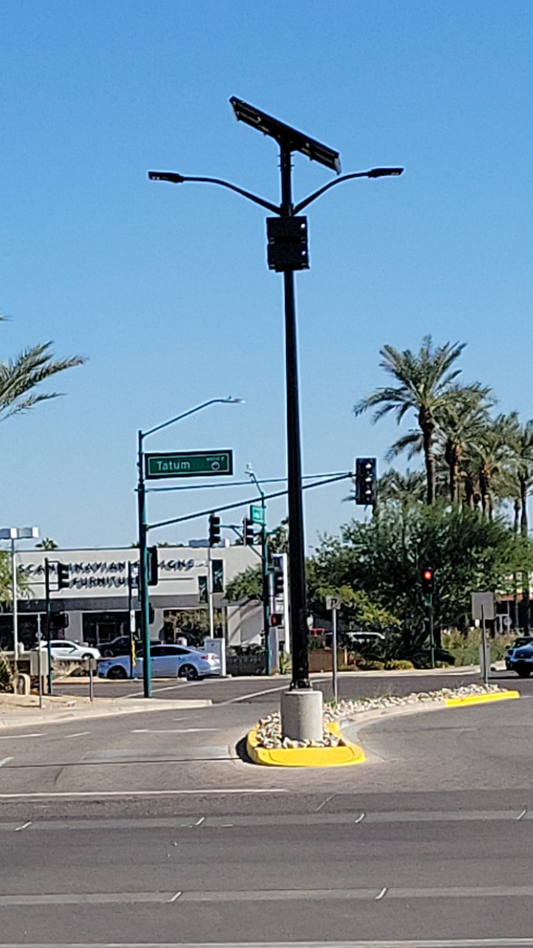 SolarPath dual-arm solar street light on a median at a desert intersection