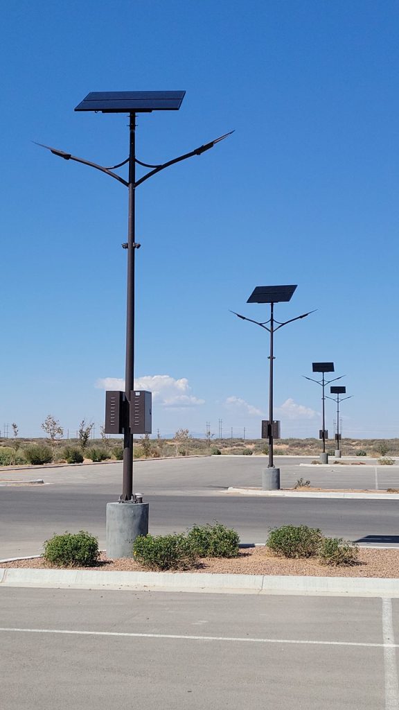 Row of SolarPath dual-arm solar street lights across a commercial parking lot