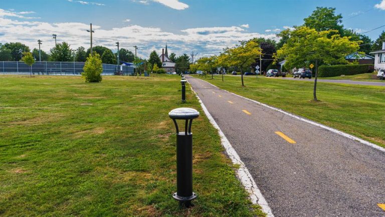 SolarPath solar bollard lighting a paved bike path at golden hour