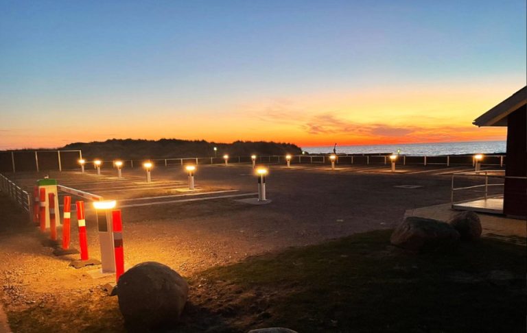 SolarPath solar bollards lighting a beachfront parking lot at sunset