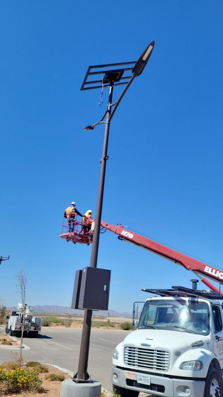 SolarPath crew installing a large solar street light from a bucket lift